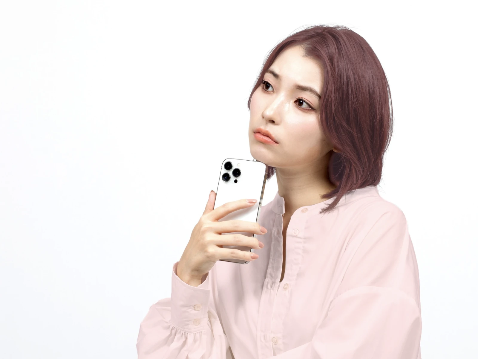 ビューティラボ/さくらピンクの髪色をしてスマホを手に持って似合う髪色について考えている女性