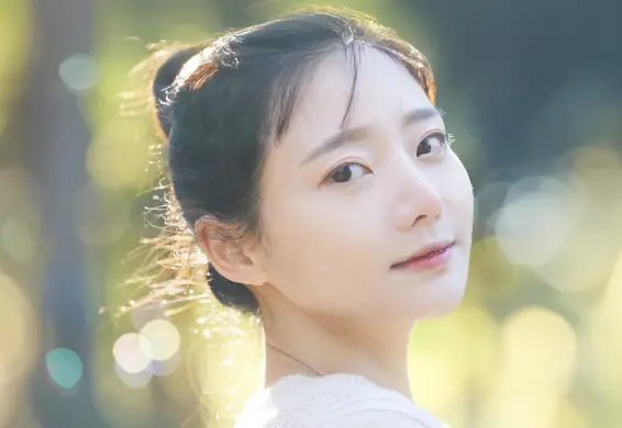 明るめのブラウン系の髪色をしてこちらを向いている女性